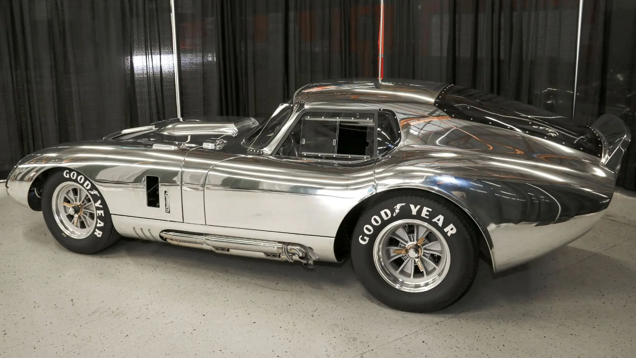 A polished Ford V8 engine gleams inside a Shelby Cobra, symbolizing its legendary performance