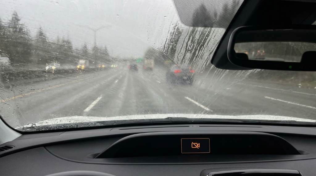Seattle street with vehicles driving safely through steady rainfall