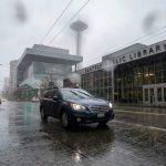 Vehicle dashboard showing driver assistance warning during heavy rain